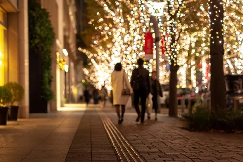 Couple walking together while viewing holiday lights in town.