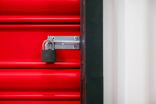 A padlock on a red self storage door.