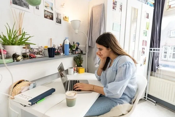 Young woman at a a desk looking at laptop